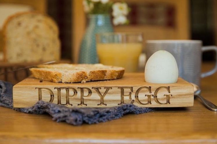 small oak platter with toast soldiers and an egg 