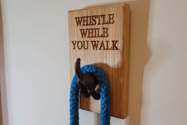 Oak Block with an cast iron tail holding a blue dog lead engraved with Whistle While You Walk 